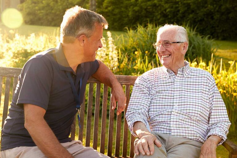 Older adults participating in a group activity around a table with smiles and conversation.